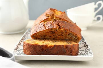 Wall Mural - cut homemade carrot cake with nuts on light grey table, closeup