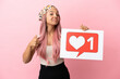 © luismolinero - Young mixed race woman with pink hair isolated on pink background holding a placard with Like icon with thumb up