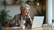 © GG Kenji - Smiling Mature Woman Enjoys Coffee While Working from Home Office