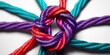© KazeDor - Braided ropes knotted together, colorful strands on white background, overhead shot