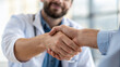 © Zuyu - close up of doctor and patient shaking hands, symbolizing trust and agreement in professional healthcare setting. background is softly blurred, emphasizing handshake