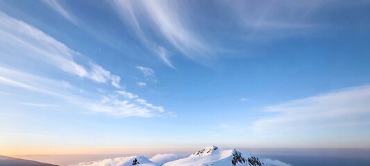 Wall Mural - snow - covered mountains, which look magnificent against the backdrop of a light - blue sky and flowing clouds. Mist shrouds the mountains, adding a touch of dreamy atmosphere.