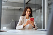 © Stock 4 You - Happy smiling hispanic business woman working on telephone mobile phone at office. Young businesswoman manager using pc cellphone technology device financial bank application sitting at workplace desk