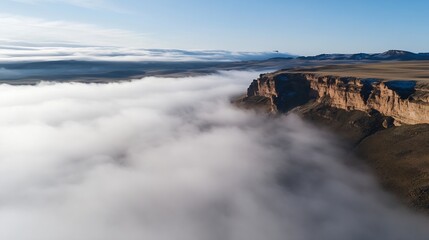Leinwandbilder - Breathtaking aerial view of majestic cliffs emerging from the dense fog on a clear day : Generative AI