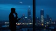 © Qbertstudio - Silhouetted businessman drinking, using mobile phone indoors at night, cityscape view through rain-streaked window. Reflects ambition, challenge, vision, success.