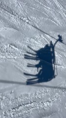 Fototapete - Shadow of a skiers going up in a ski lift in a ski resort in French alps.