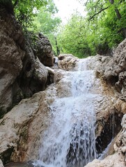 Poster - Breathtaking Image of a Waterfall Cascading Down Rocky Terrain Surrounded by Greenery : Generative AI