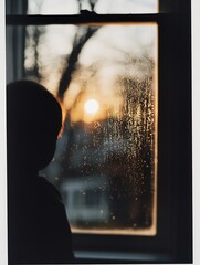 Aufkleber - Silhouette of a child gazing at a sunset through a fogged window creating a nostalgic scene : Generative AI