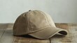 © RIVALDI - Beige baseball cap on rustic wooden table.