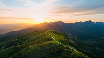 Aufkleber - breathtaking aerial view of rolling hills at sunset with a winding path disappearing into the mounta