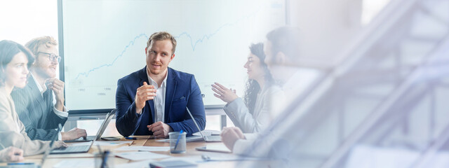 Aufkleber - A group of business professionals are seated around a conference table, engaged in a discussion. They are gathered in a modern office with a large whiteboard behind them