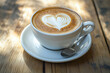 © MuhammadArshad - Cup of cappuccino with heart latte art on a wooden table, close-up view
