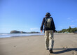 © Janice - Man walking on Castlepoint beach. Castlepoint lighthouse in the distance. Wairarapa.