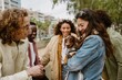 © Drobot Dean - A young Asian woman in her late 20s, petting and holding her small dachshund dog as she stands among a diverse group of her four young friends, on a city street, outside