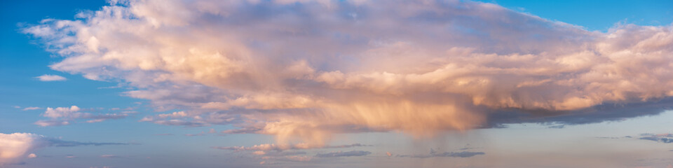 Wall Mural - Panoramic background of beautiful evening sky with rain shower and clouds at sunset	