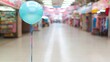© Mahavira Osa - Single Teal Balloon in a Blurred Shopping Mall