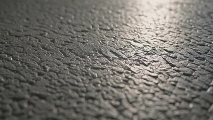 Poster - Textured concrete surface illuminated by shifting light reflections in motion