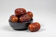 © PixelPerfect - Brown Dates Filled in Black Bowl Filled White Surface