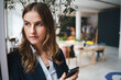 © Westend61 - Businesswoman using smartphone in modern office setting