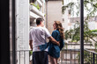 © Westend61 - Couple enjoying a morning together on a balcony in an urban setting