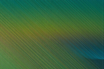 Aufkleber - Diagonal lines in shades of green and yellow blend into blue, creating a vibrant gradient background with a textured, abstract design.