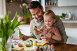 © Halfpoint - Little boy and father painting eggs with brush and easter egg dye.