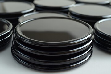 Poster - Stack of glossy black coasters arranged neatly on a table showing smooth surfaces and clean lines