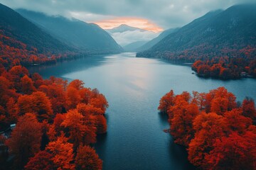 Aufkleber - Autumn sunset over tranquil lake surrounded by vibrant orange trees in a mountainous landscape