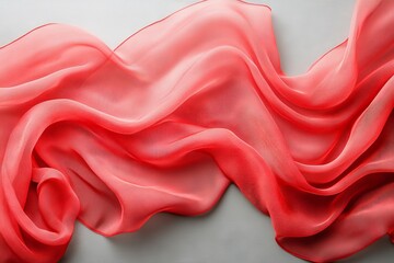 Poster - Flowing coral chiffon fabric drapes gracefully on a light surface for delicate design inspiration
