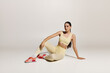 © LIGHTFIELD STUDIOS - Sporty young woman in stylish athletic wear poses gracefully in a minimalist studio setting