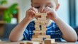 © Kannika - children critical thinking. A child builds a tower with wooden blocks, showcasing focus and creativity.