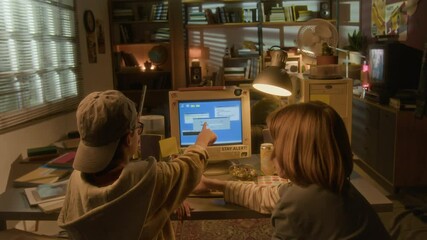 Wide angle back view of two boys using retro computer in warm toned 90s room setting