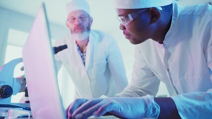Wall Mural - two scientists, an african man and a caucasian man, collaborate in a laboratory, examining data on a