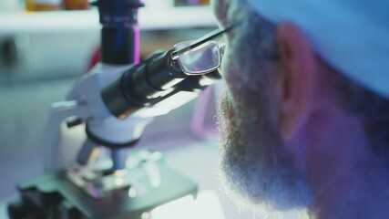 Wall Mural - dedicated scientist wearing lab coat and glasses carefully examining sample through advanced microsc
