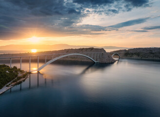 Wall Mural - aerial view of bridge and blue sea at colorful sunset. modern krk bridge island during golden hour, 
