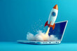 © sornram - A stylized rocket launching from a laptop, symbolizing innovation, creativity, and digital progress in a vibrant blue background.