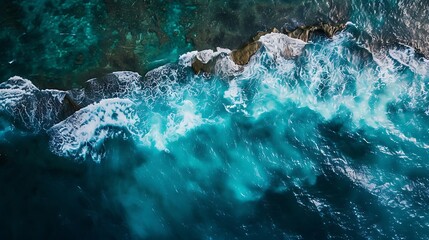 Wall Mural - aerial view of sea shore with blue waves crashing to the rocks