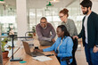 © mavoimages - Diverse group of smiling businesspeople working together around a laptop