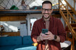 © Migma_Agency - Happy man using smartphone at home, child playing upstairs