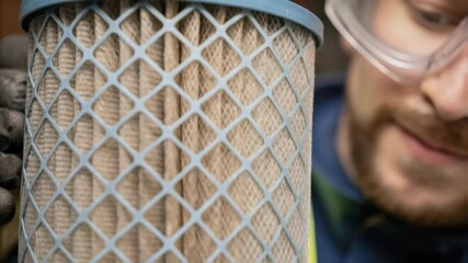 Aufkleber - A closeup of a technician wearing safety goggles closely inspecting a mesh filter with fibers and debris vividly highlighted against the backdrop.