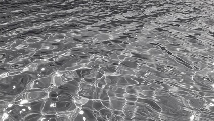 Poster - Rippling water surface creating abstract patterns in monochrome hues during daylight