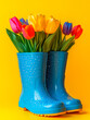 © Elen Moulin - Bright blue rain boots filled with colorful tulips celebrate the essence of spring against a cheerful yellow backdrop