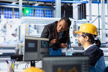 Poster - man and woman working in photovoltaics factory optimizing production flow. african american manager 