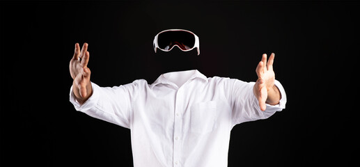 Poster - A user in a white shirt is immersed in virtual reality, wearing goggles while gesturing with hands. The background is completely dark, emphasizing the technology and user involvement.