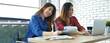 © aFotostock - Banner Happiness two women working together confident team meeting in office desk. Team business partners working laptop startup company. Asian colleague friendship at home office with copy space