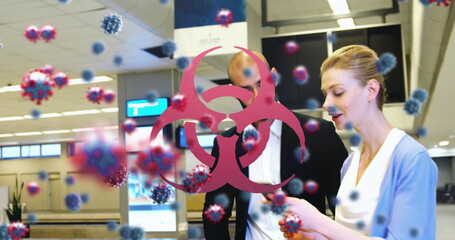 Poster - People at airport checking phone with virus particles and biohazard symbol overlay