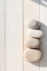Poster - serene arrangement of decorative stones on textured wooden surface with gentle natural light casting soft shadows
