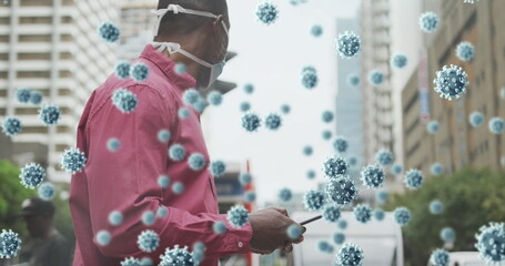 Poster - Multiple covid 19 cells floating against man wearing face mask using smartphone on the street