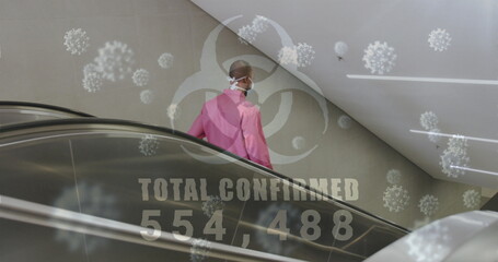 Poster - Biohazard symbol with increasing cases against african american senior manusing escalator