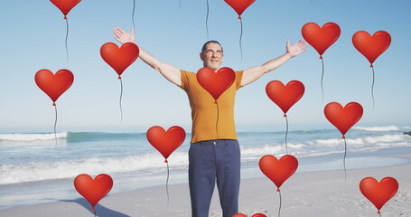 Poster - Image of red heart love balloons digital icons over smiling senior man on beach